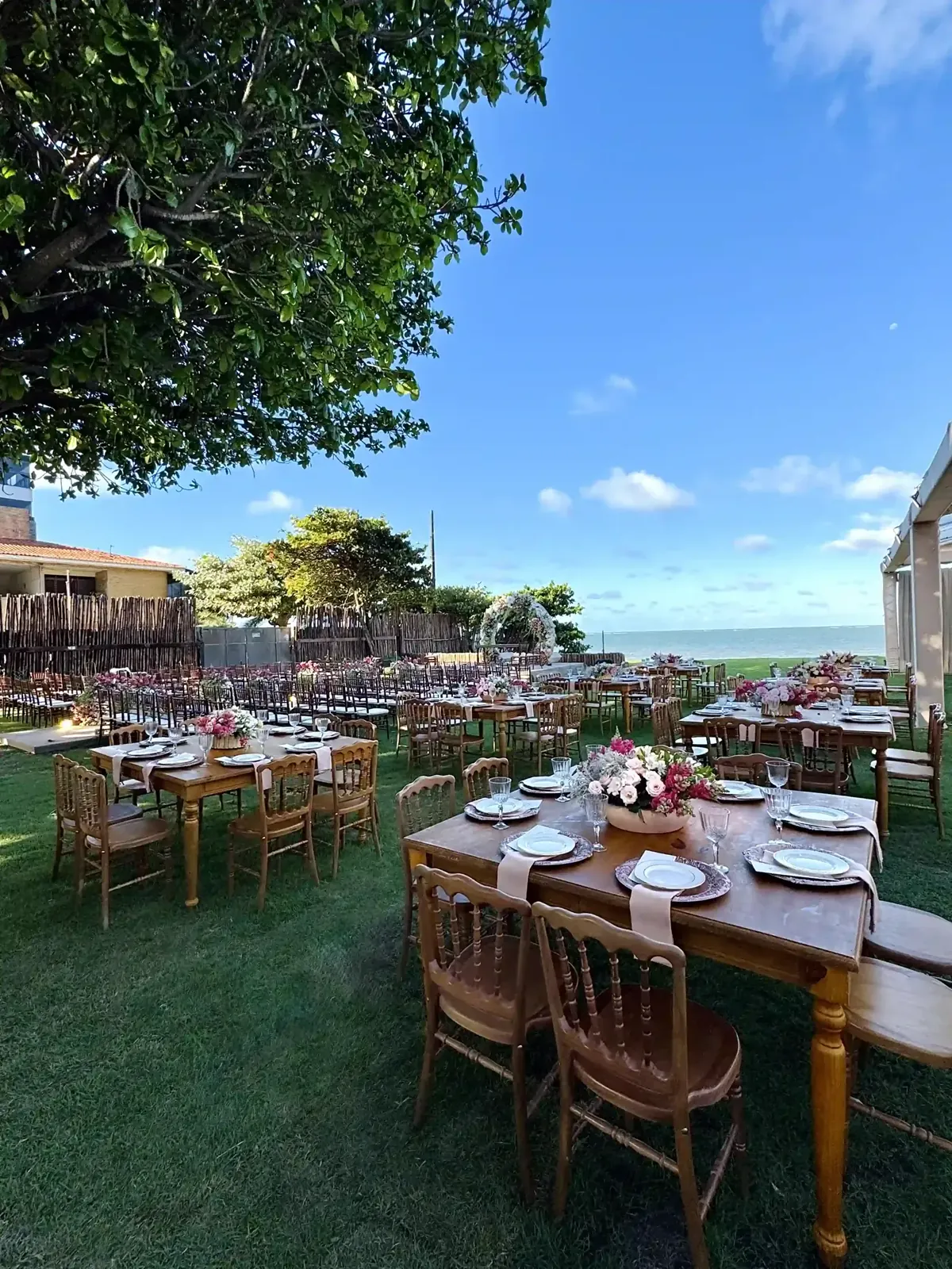 Mesa de casamento com flores vermelhas e luminárias de palha no UNIQUE Beach