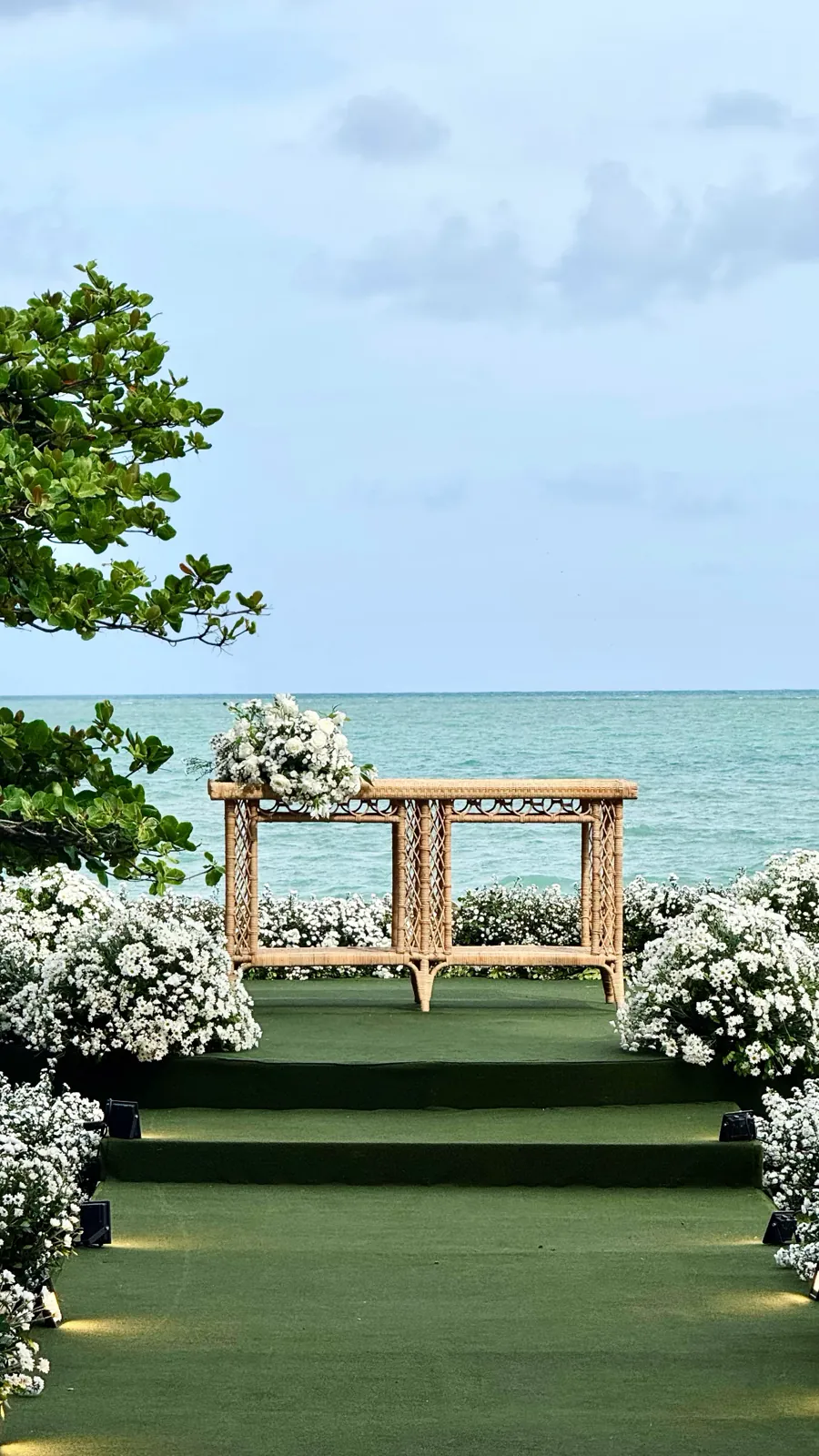 Altar de vime com flores brancas de frente para o mar no UNIQUE Beach